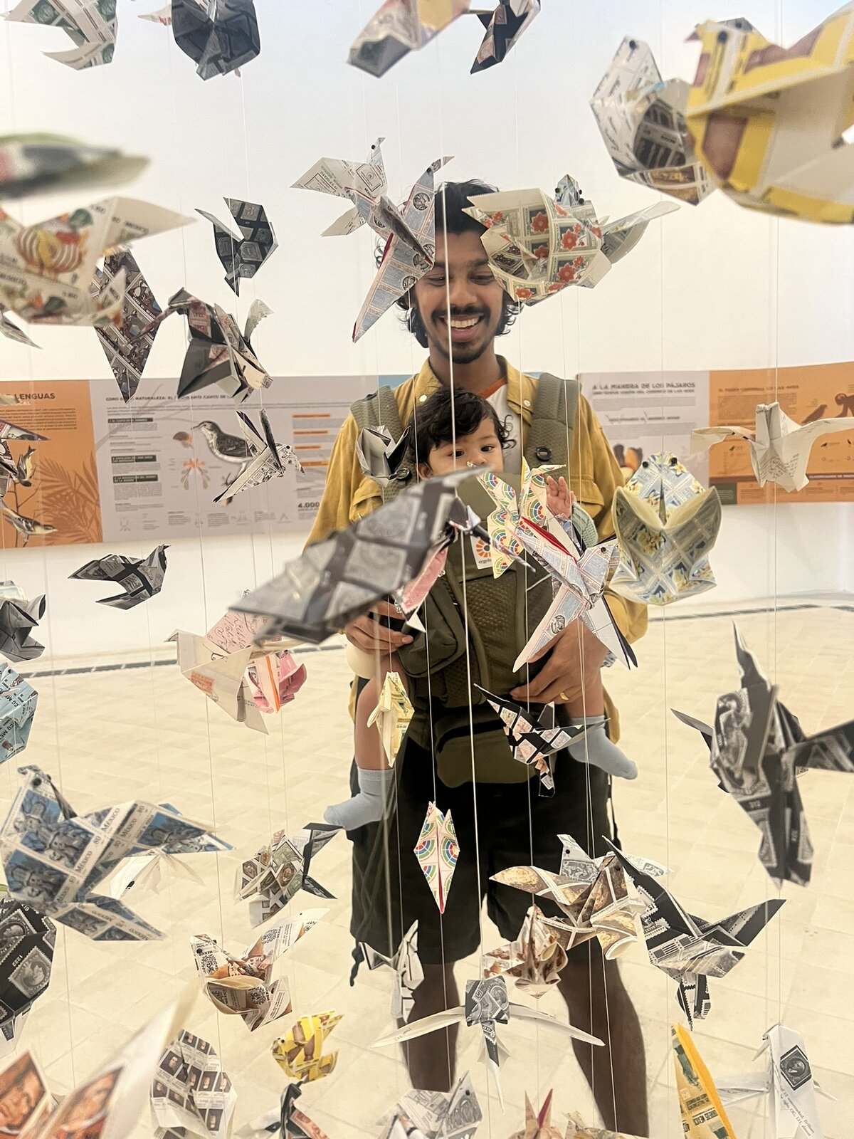 Tareque smiling with his daughter at a paper-bird art installation